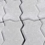 Koadel Building Solutions Close-up view of interlocking concrete pavers with a geometric pattern, perfect for outdoor pavements.