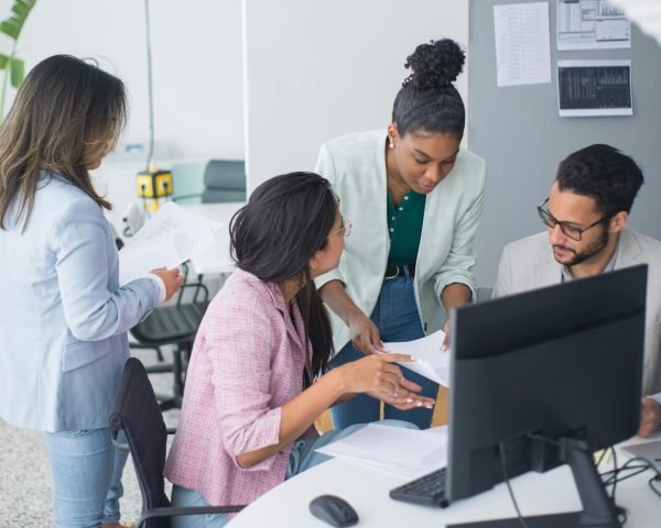 A diverse team engaged in a lively discussion in a modern office setting, fostering collaboration and teamwork.