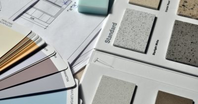Color palette and material samples for interior renovation projects on a blueprint.